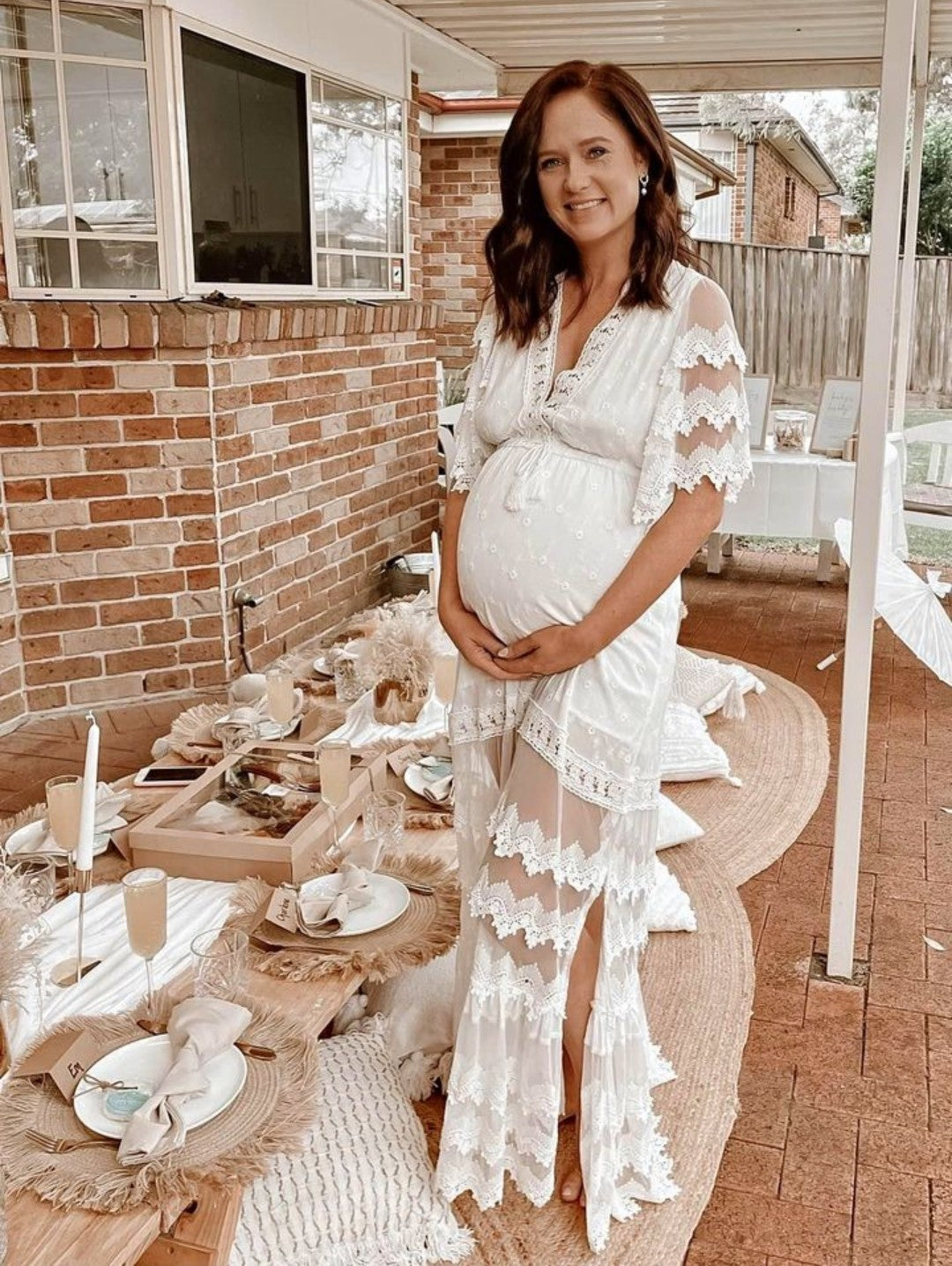 Pregnant mum wears a white lace maternity dress during her boho inspired baby shower