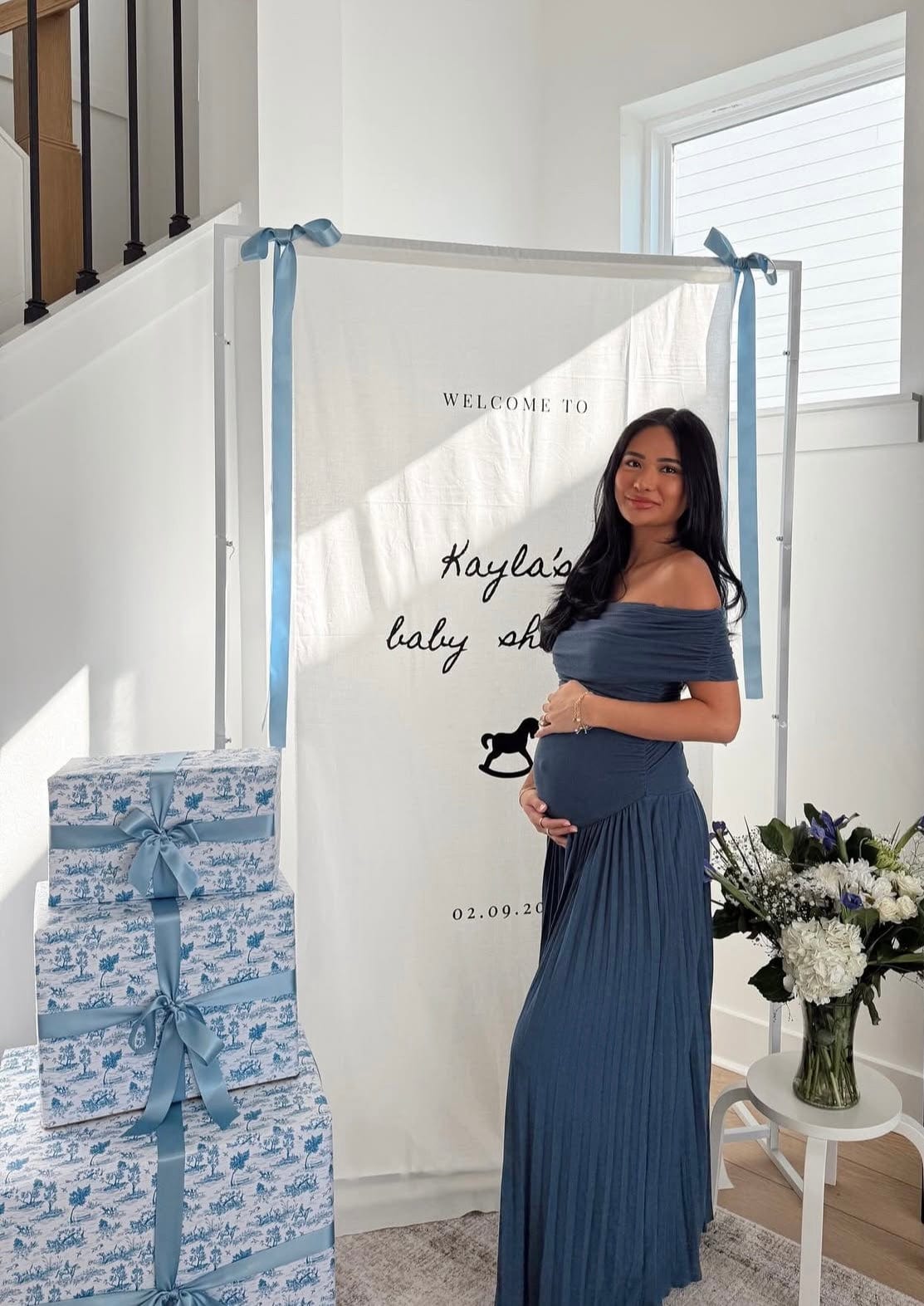 Pregnant mother celebrating during her baby shower wearing Everything Lace Hire Field of Dreams Baby Shower Dress in navy