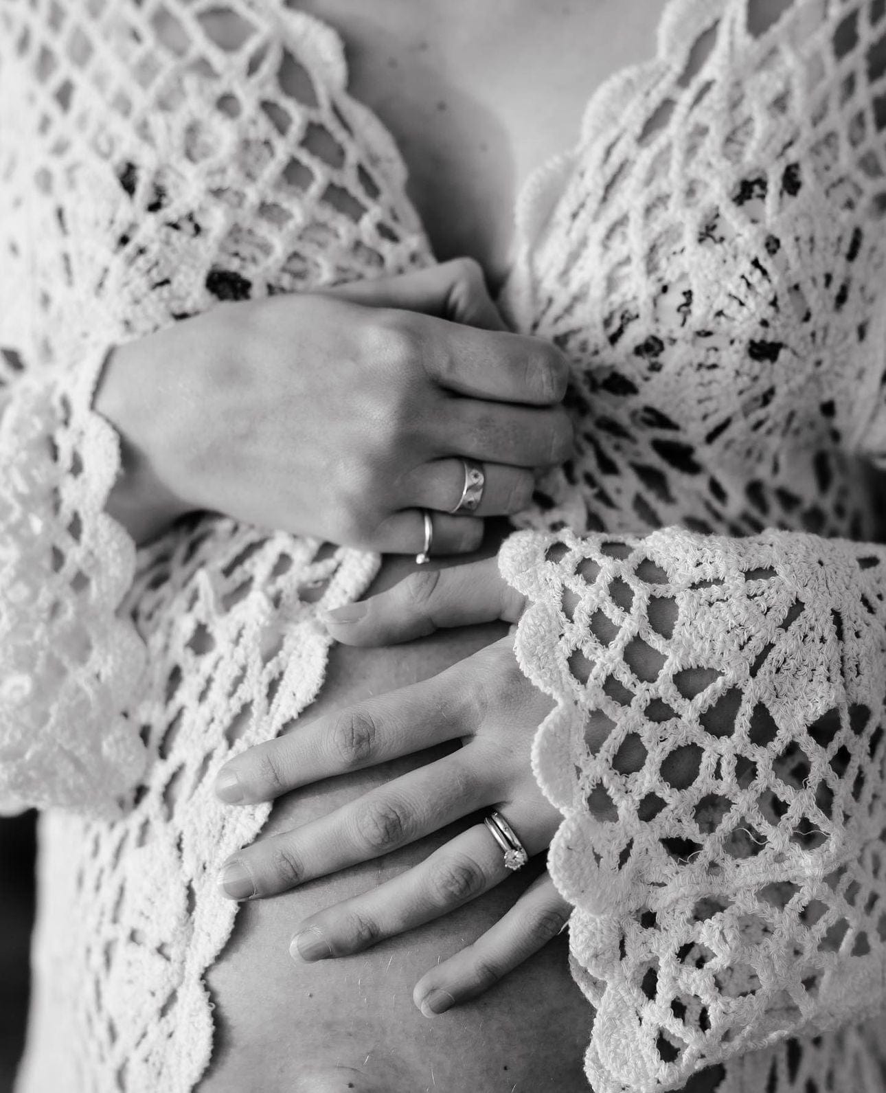 A pregnant lady puts her hands over her pregnancy bump wearing Everything Lace Hire Maternity Photoshoot Robe