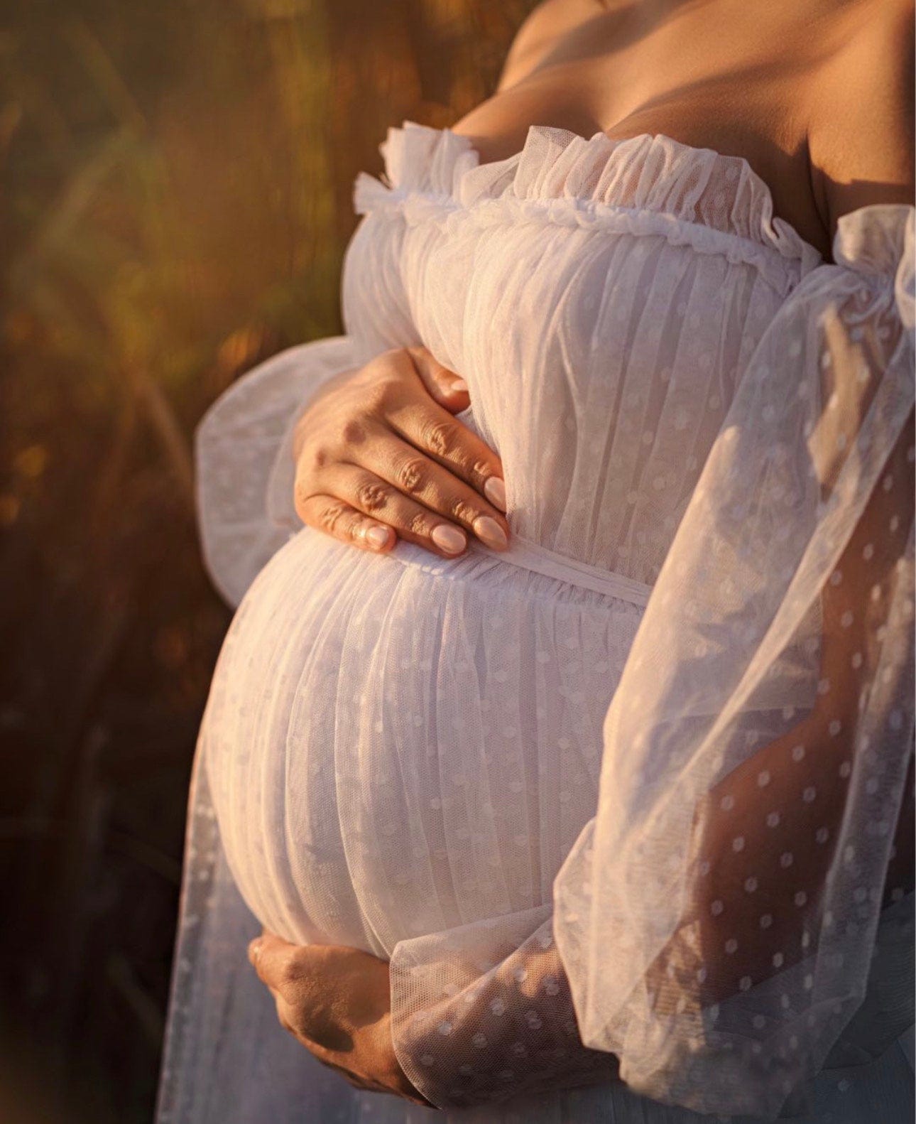 Pregnant lady during her maternity photoshoot cups her pregnant belly wearing Everything Lace Hire Isadora Tulle Maternity Maxi Gown