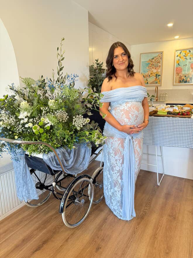 Pregnant lady wearing the Gracie Maxi Twist dress in pale blue – flowing maternity maxi dress perfect for baby showers, gender reveals, and special occasions.