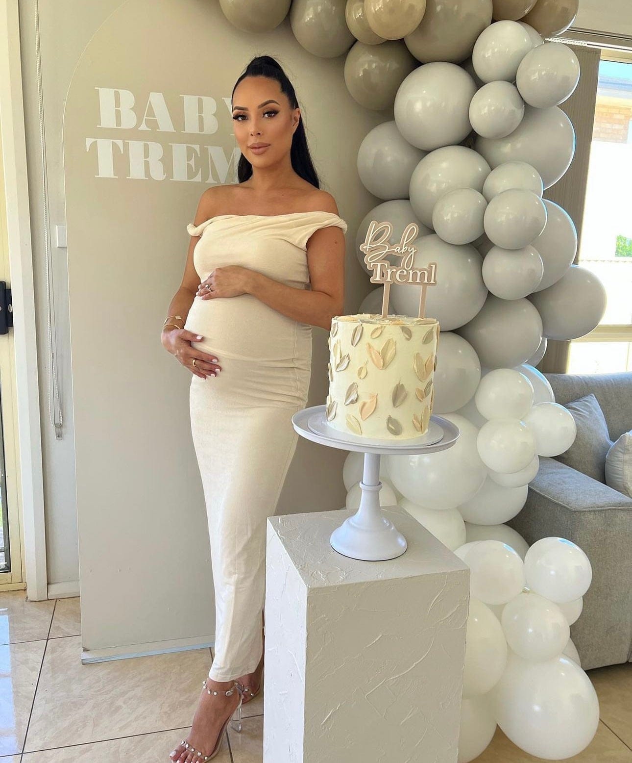 A pregnant lady is celebrating her baby shower wearing Everything Lace Hire Johansen Poppy Dress in white