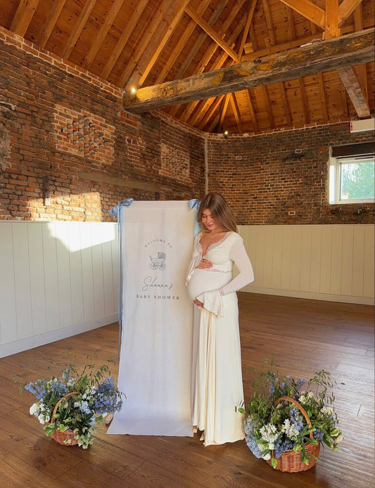 A pregnant woman wearing Everything Lace Hire Meshki Electra Dress n Ivory for her Baby Shower
