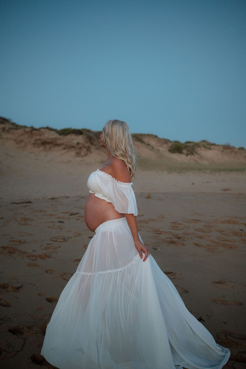 Maternity Photoshoot on the beach wearing Everything Lace Hire Amara Two Piece Maternity Dress that is long and flowy