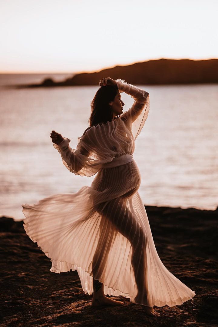 a pregnant lady during her maternity photoshoot at the beach arms in the air wearing Everything Lace Hire Maternity Photoshoot Dress