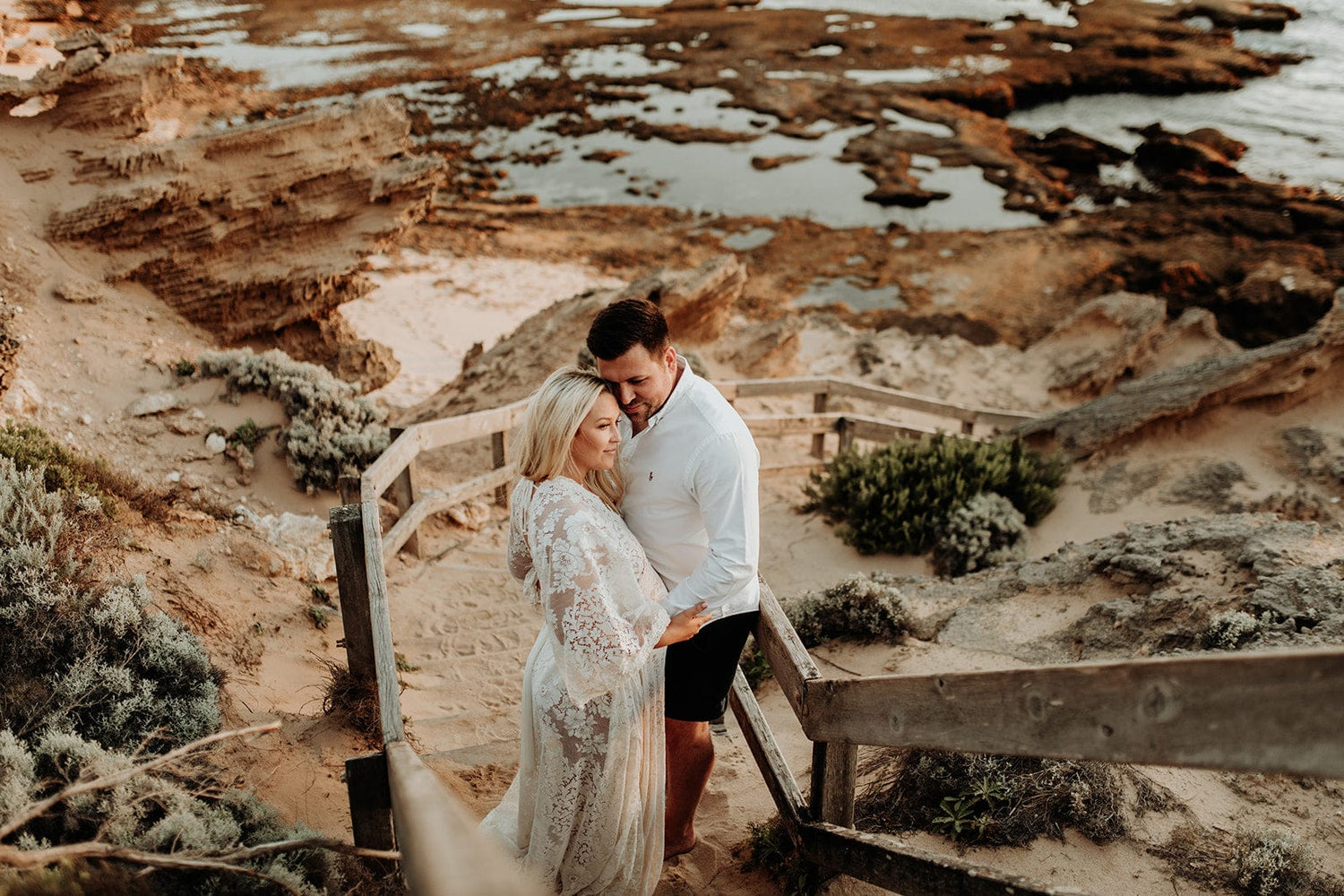 Pregnant mumma standing on a beach in a stunning lace dress