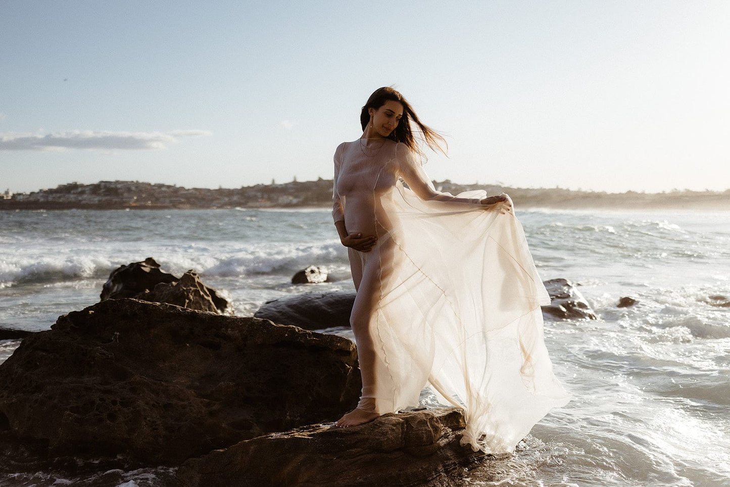 Pregnant Woman in Ivory Vienna Maternity Dress during her sunset maternity photoshoot