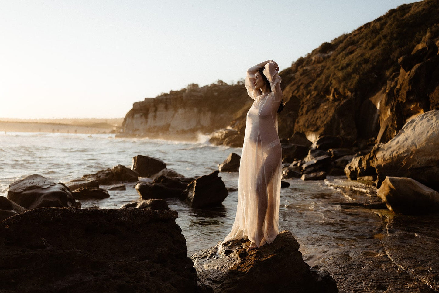 Pregnant lady wearing the Vienna Gown, a long flowy maternity dress for photoshoots