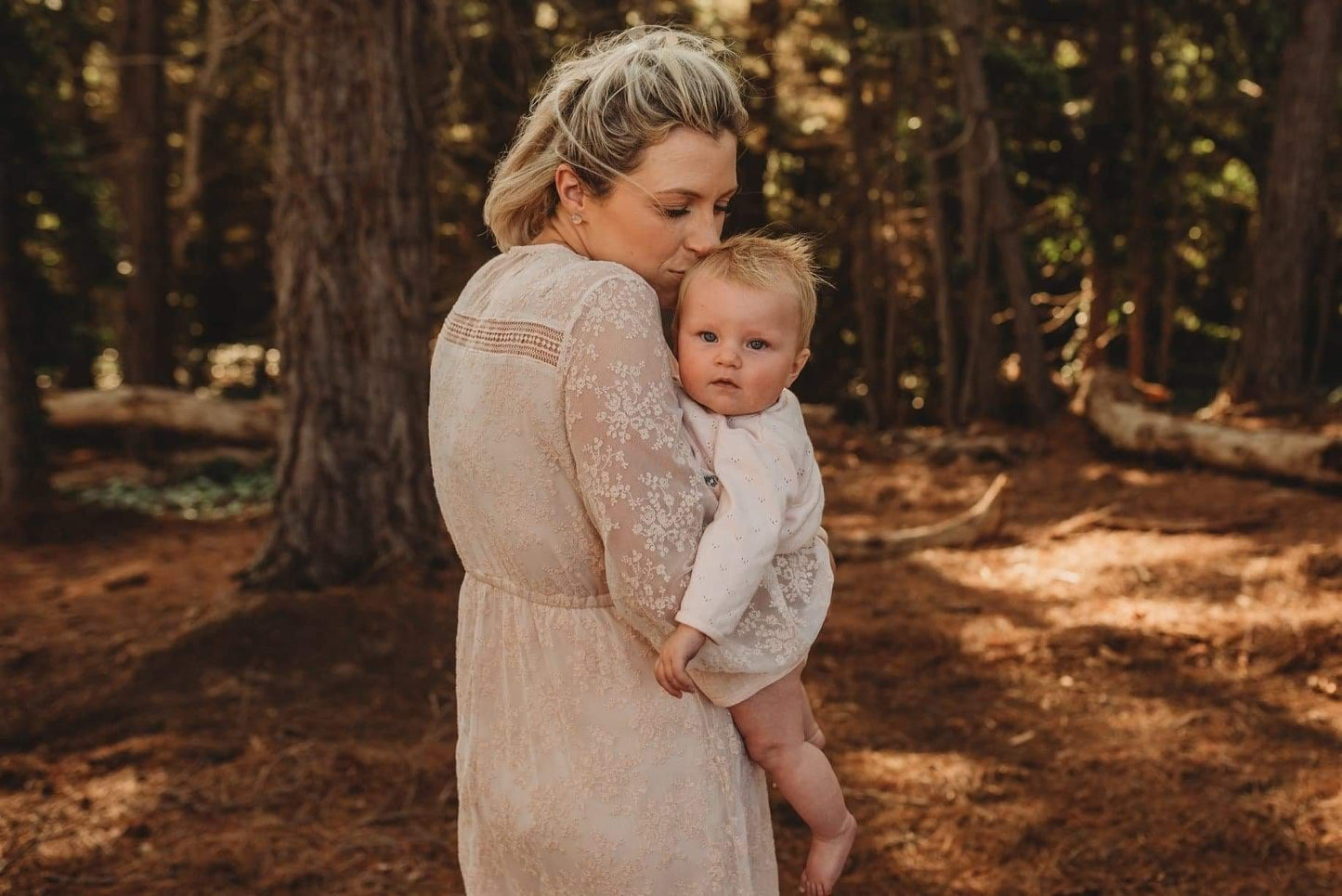 Mumma holding baby during family photoshoot wearing blush lace dress