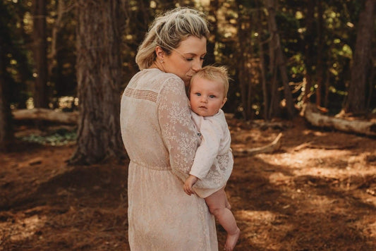 Mumma holding baby during family photoshoot wearing blush lace dress
